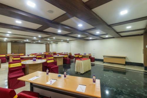 a conference room with tables and chairs and a podium at The Metropole by Keyboard Hotels in Lonavala