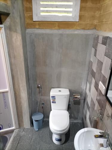 a small bathroom with a toilet and a sink at DiDi Eco Home in Weligama