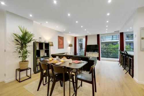 a dining room and living room with a table and chairs at Les Lilas Mon Amour! in Les Lilas