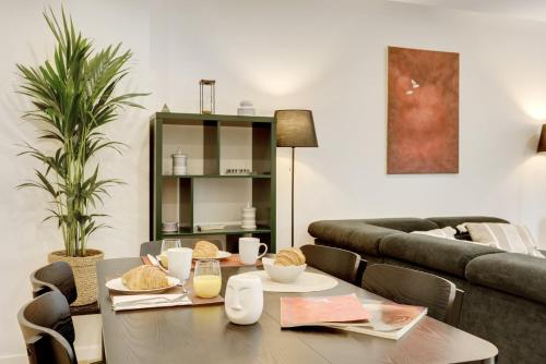 a living room with a table and a couch at Les Lilas Mon Amour! in Les Lilas