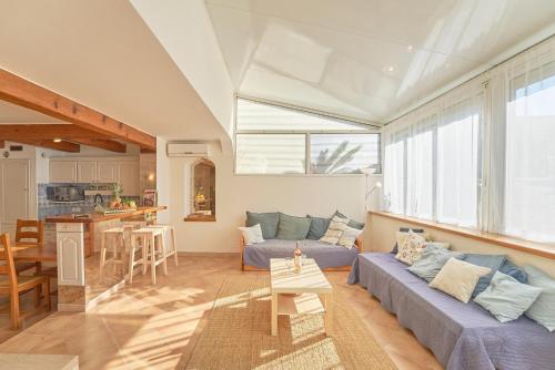 un salon avec un canapé bleu et une cuisine dans l'établissement Escapade à Six-Fours - Plage, terrasse & parking, à Six-Fours-les-Plages