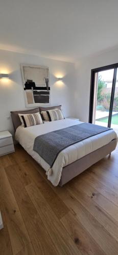 une chambre avec un grand lit et une grande fenêtre dans l'établissement Casa di Leccia, Superbe Villa à proximité immédiate des plages, piscine privée, à Lecci