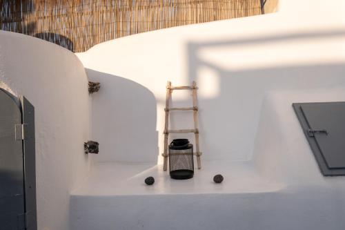 a ladder sitting on the side of a white wall at Noelia Suites in Oia