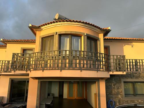 a yellow house with a balcony on top of it at Rose Sun House in Ponta do Sol
