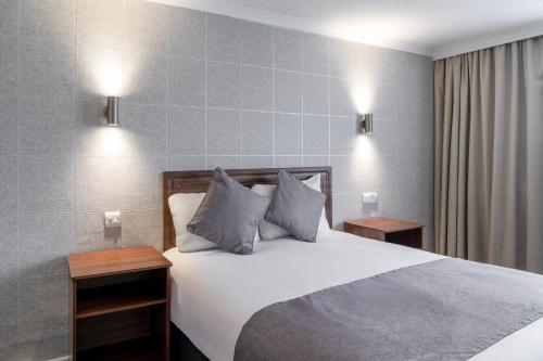 a bedroom with a white bed with two night stands at Airport Hotel Manchester in Manchester