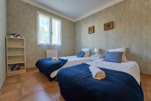 une chambre avec deux lits et une fenêtre dans l'établissement Escapade à Six-Fours - Plage, terrasse & parking, à Six-Fours-les-Plages