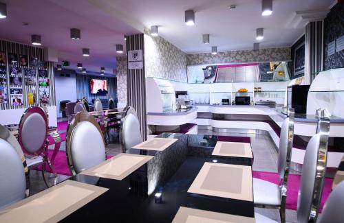 Un restaurante con mesas y sillas y un bar. en Palermó Panzio, en Nyíregyháza