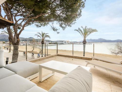 a living room with white furniture and a view of a beach at Apartment Colorado 1A By SunVillas Mallorca in Port de Pollensa