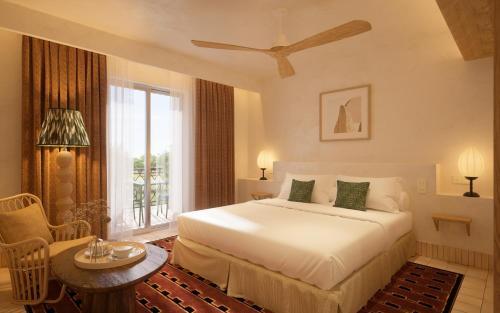 a bedroom with a bed and a table and a window at Hôtel Maison Chiberta I Ouverture été 2025 in Anglet