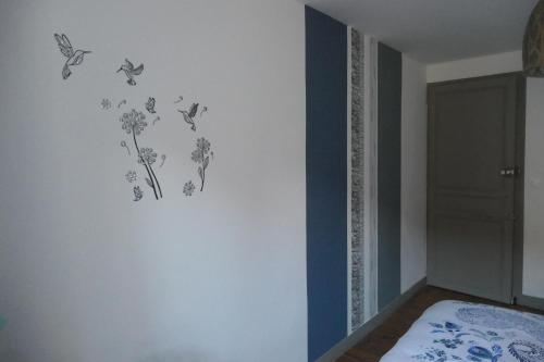 a bedroom with butterflies and flowers on the wall at Chambres d'Hôtes Colibri in Arthez-de-Béarn