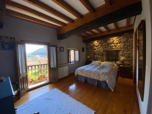 a bedroom with a bed and a stone wall at Casa Los Josuco in Collado