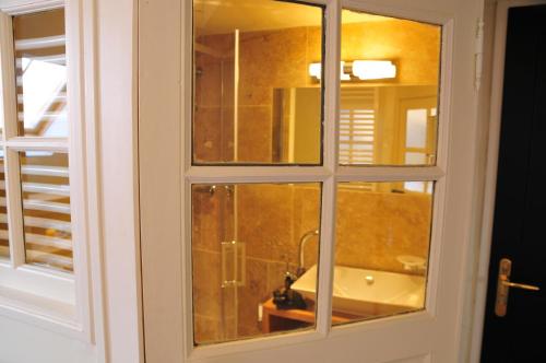 a bathroom window with a tub and a sink at Les Glycines Vézelay in Vézelay