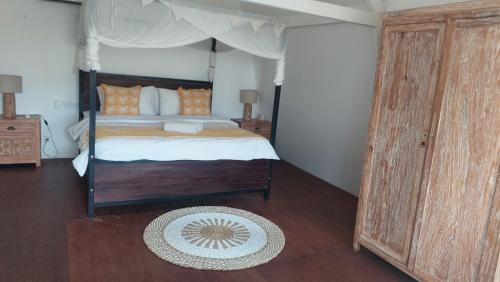a bedroom with a canopy bed and a rug at Villa Olivia in Seminyak