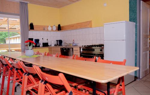 a kitchen with a long wooden table and orange chairs at Hostel Waldhaus am Ferienpark Gruppenhaus in Mirow