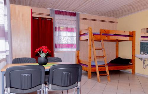 a room with a table and chairs and a bunk bed at Hostel Waldhaus am Ferienpark Gruppenhaus in Mirow