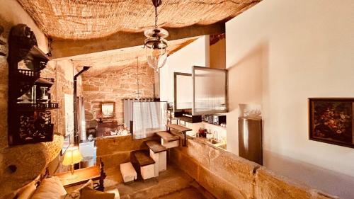 a living room with a stone wall and a chandelier at Los Lagares Manor House in Deán Pequeño