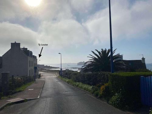 une rue vide avec vue sur l'océan dans l'établissement Ty Louise Maison de famille 10 pers bord de mer, à Plougasnou