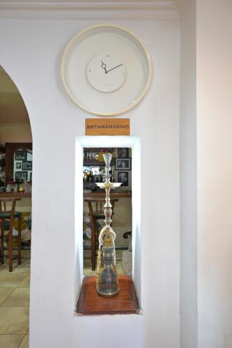 a clock on a wall in a room at Hotel Brajas in Antananarivo