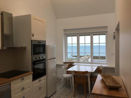 - une cuisine avec une table et une cuisine avec vue sur l'océan dans l'établissement Gwaskedou, sea view, beach and city center, à Roscoff