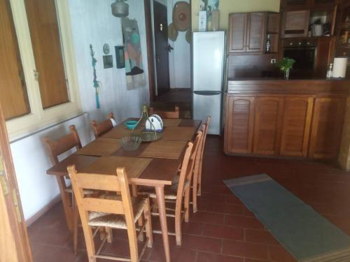 a kitchen with a wooden table with chairs and a refrigerator at 4BR by the Sea, Family friendly, Breathtaking View in Avia
