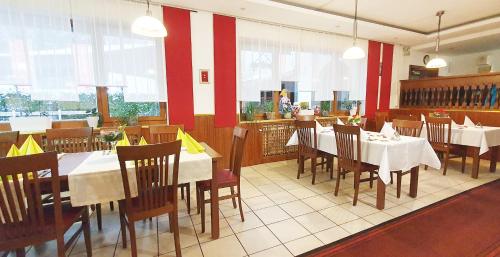 a dining room with tables and chairs in a restaurant at Mühlwinkler Hof in Bergen
