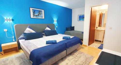 a blue bedroom with a large bed with blue pillows at Mühlwinkler Hof in Bergen
