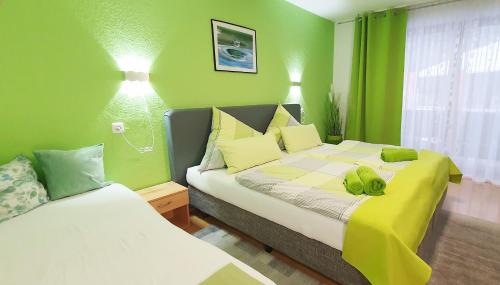 a bedroom with two beds with green walls at Mühlwinkler Hof in Bergen