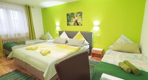 a bedroom with two beds with green walls at Mühlwinkler Hof in Bergen