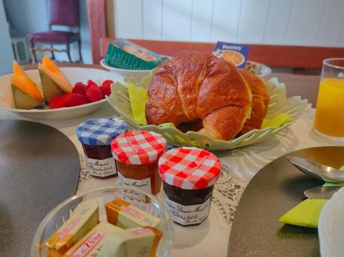 a table topped with a plate of bread and fruit at L'ancienne Gendarmerie in Saint-Laurent-sur-Gorre