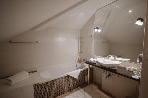 a bathroom with a sink and a bath tub and a sink at Hotel Solisko in Štrbské Pleso