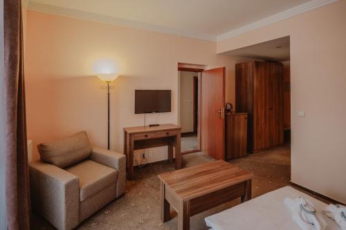 a living room with a couch and a television at Hotel Solisko in Štrbské Pleso