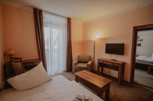 a hotel room with a bed and a television at Hotel Solisko in Štrbské Pleso