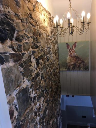 a picture of a rabbit on the wall of a bathroom at Ballintoy old school house in Ballintoy