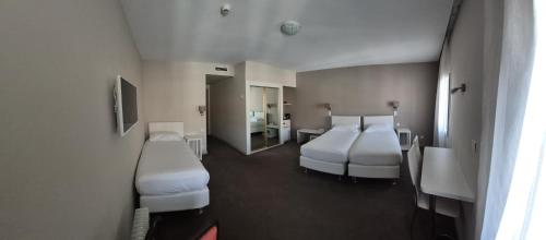 Ένα ή περισσότερα κρεβάτια σε δωμάτιο στο Hôtel Ligure