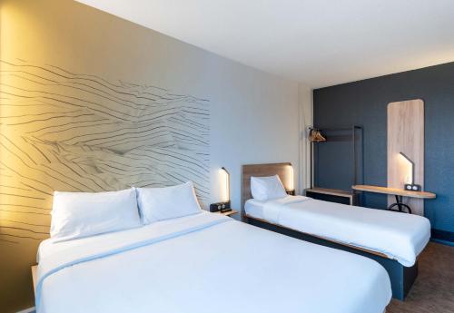 two beds sitting next to each other in a room at B&B HOTEL Lille Grand Stade in Villeneuve d'Ascq
