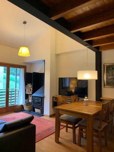 een woonkamer met een houten tafel en een eetkamer bij La Molina Alp c Puigmal in Girona