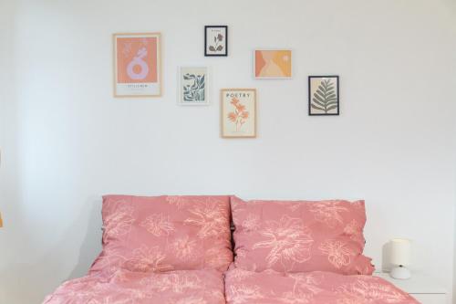 ein rosafarbenes Sofa in einem Zimmer mit Bildern an der Wand in der Unterkunft Cozy Retreat by Wenceslas Square in Prag