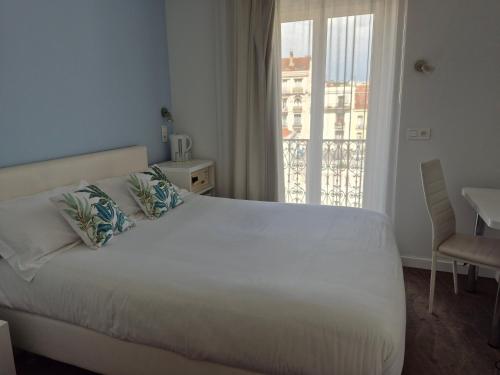 Ένα ή περισσότερα κρεβάτια σε δωμάτιο στο Hôtel Ligure