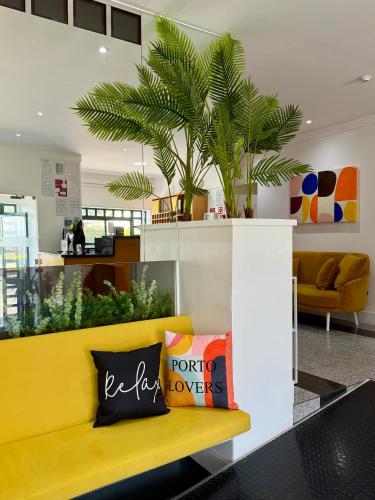 a yellow couch in a lobby with at Residencial Dona Teresa in Maia