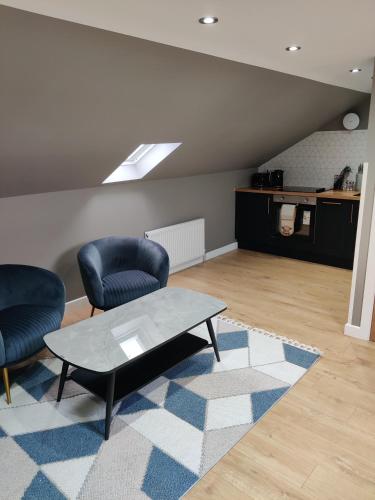a living room with two chairs and a coffee table at Signature Apartments in Fraserburgh