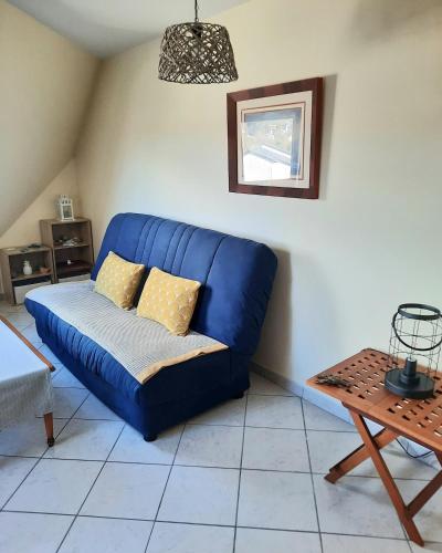 a blue couch in a living room with a table at Trez-Hir Appartement 4 pers bord de mer in Plougonvelin