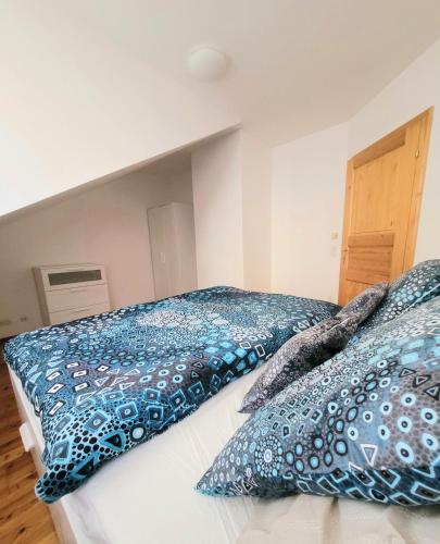 a bedroom with two beds with blue and white pillows at ShalalaLiving Apartments Mariazell in Mariazell