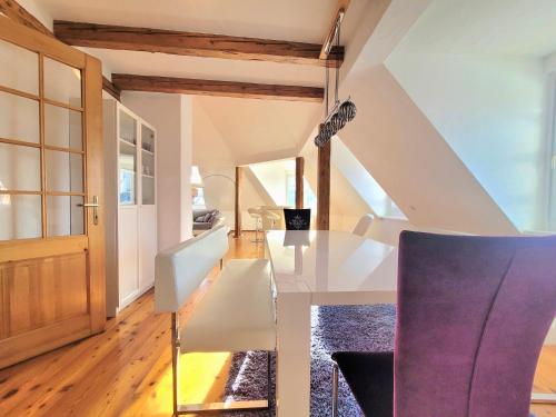 a dining room with a glass table and purple chairs at ShalalaLiving Apartments Mariazell in Mariazell