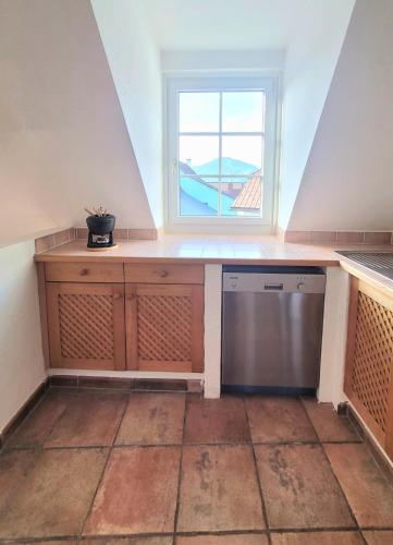 an attic kitchen with a window and a dishwasher at ShalalaLiving Apartments Mariazell in Mariazell