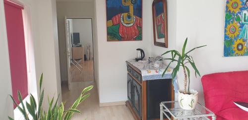 un salon avec un canapé rouge et une table dans l'établissement Chez Isabelle et Bernard, à La Flocellière