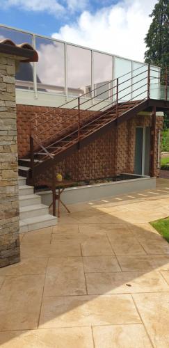 - un bâtiment en briques avec un escalier et un balcon dans l'établissement Chez Isabelle et Bernard, à La Flocellière