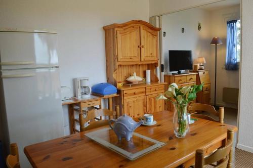 une cuisine avec une table en bois et un vase de fleurs. dans l'établissement Appart 2 pièces 4 couchages ARGELES SUR MER AR450-0912, à Argelès-sur-Mer