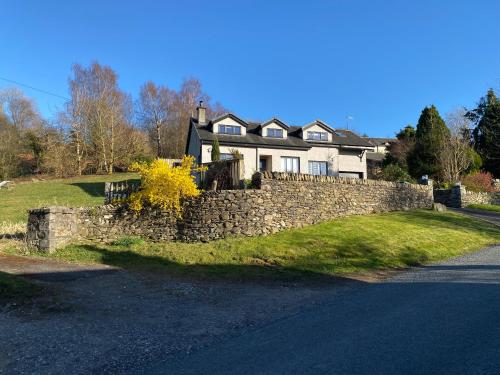 a stone retaining wall in front of a house at Bishop Fell in Newby Bridge