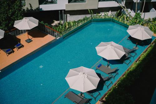 an overhead view of a swimming pool with umbrellas at Andaman Beach Hotel Phuket - Handwritten Collection in Patong Beach