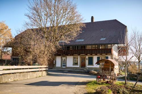 a house with a black roof on a street at Uelis-Stöckli-Gästezimmer auf Bauernhof mit Billiard und Alpakatrekking in Meikirch